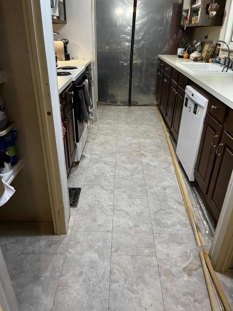 A new engineered vinyl tile floor in a galley kitchen in an almost complete renovation