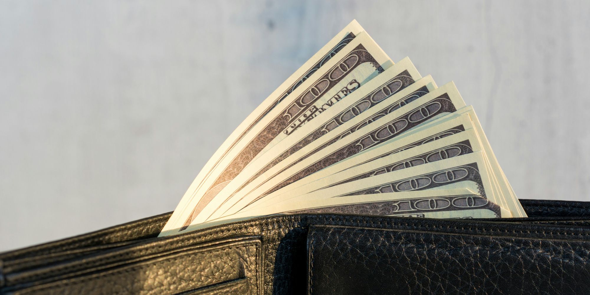 Money in a wallet after increased home value from a remodel in Hampton, NH