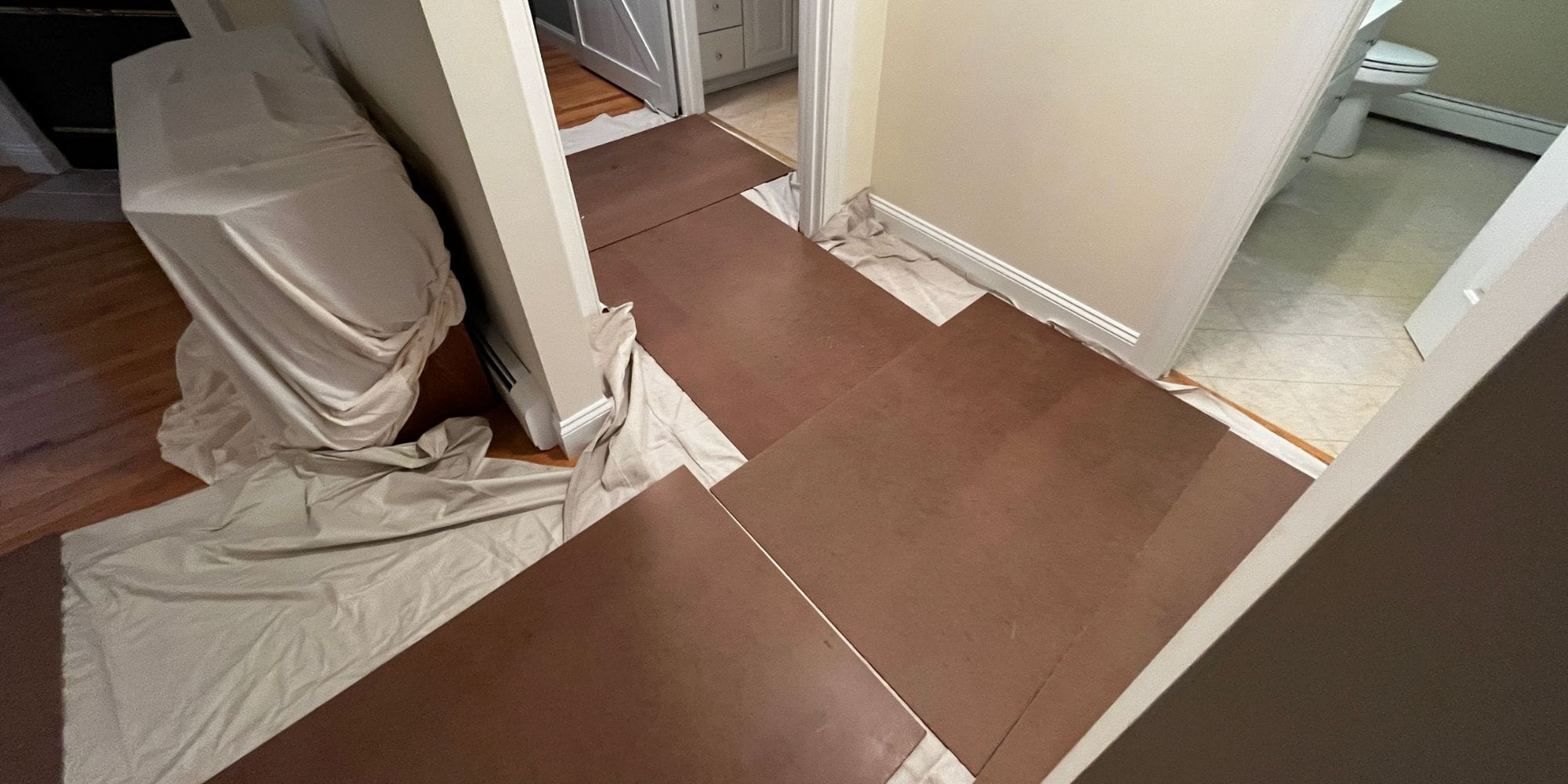 Floor protection and drop cloths on furniture in preparation for a bathroom remodel in Portsmouth, NH