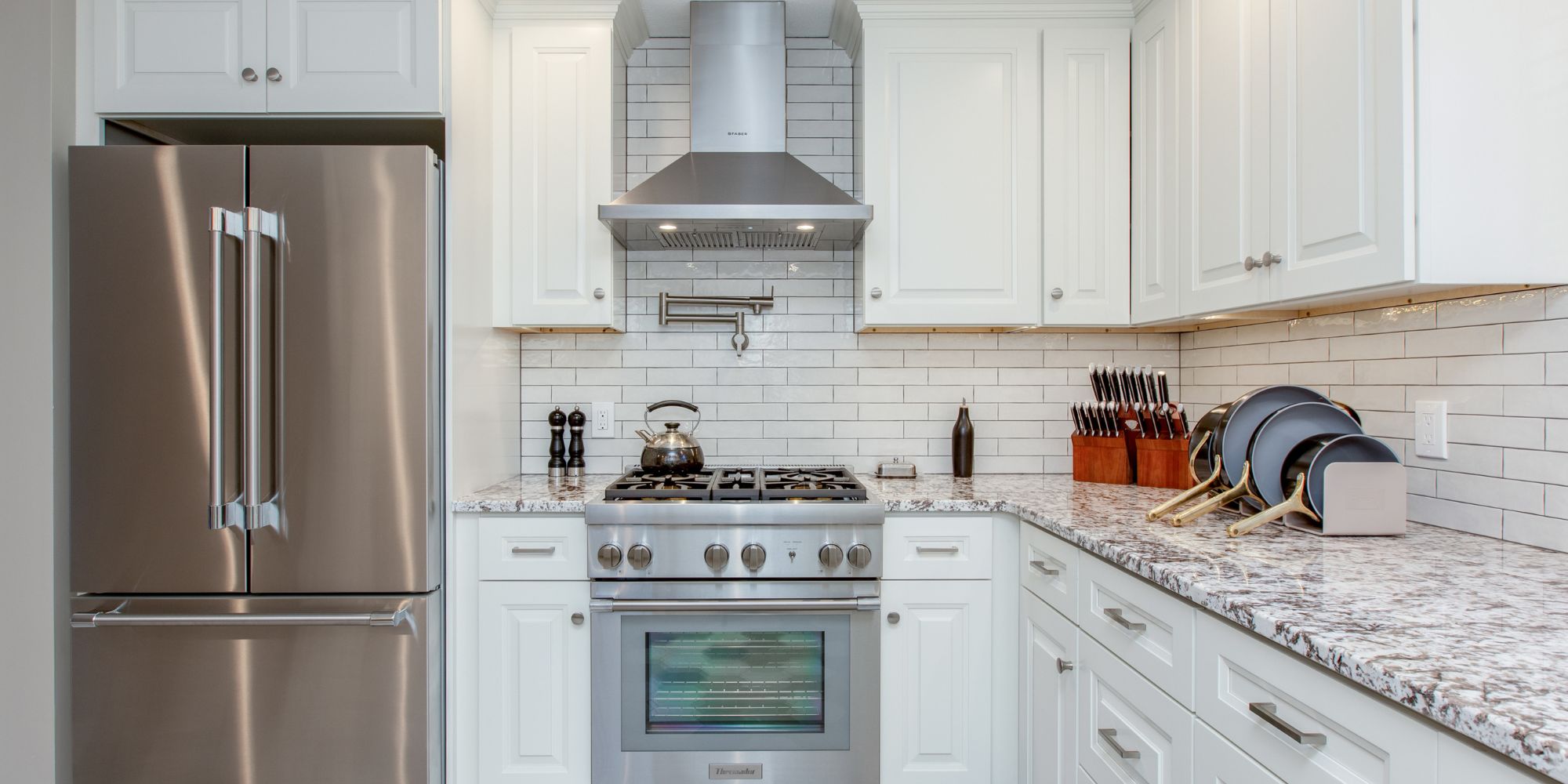 Custom kitchen renovation in Portsmouth, NH with granite countertops, Thermador high-end appliances, and tile backsplash