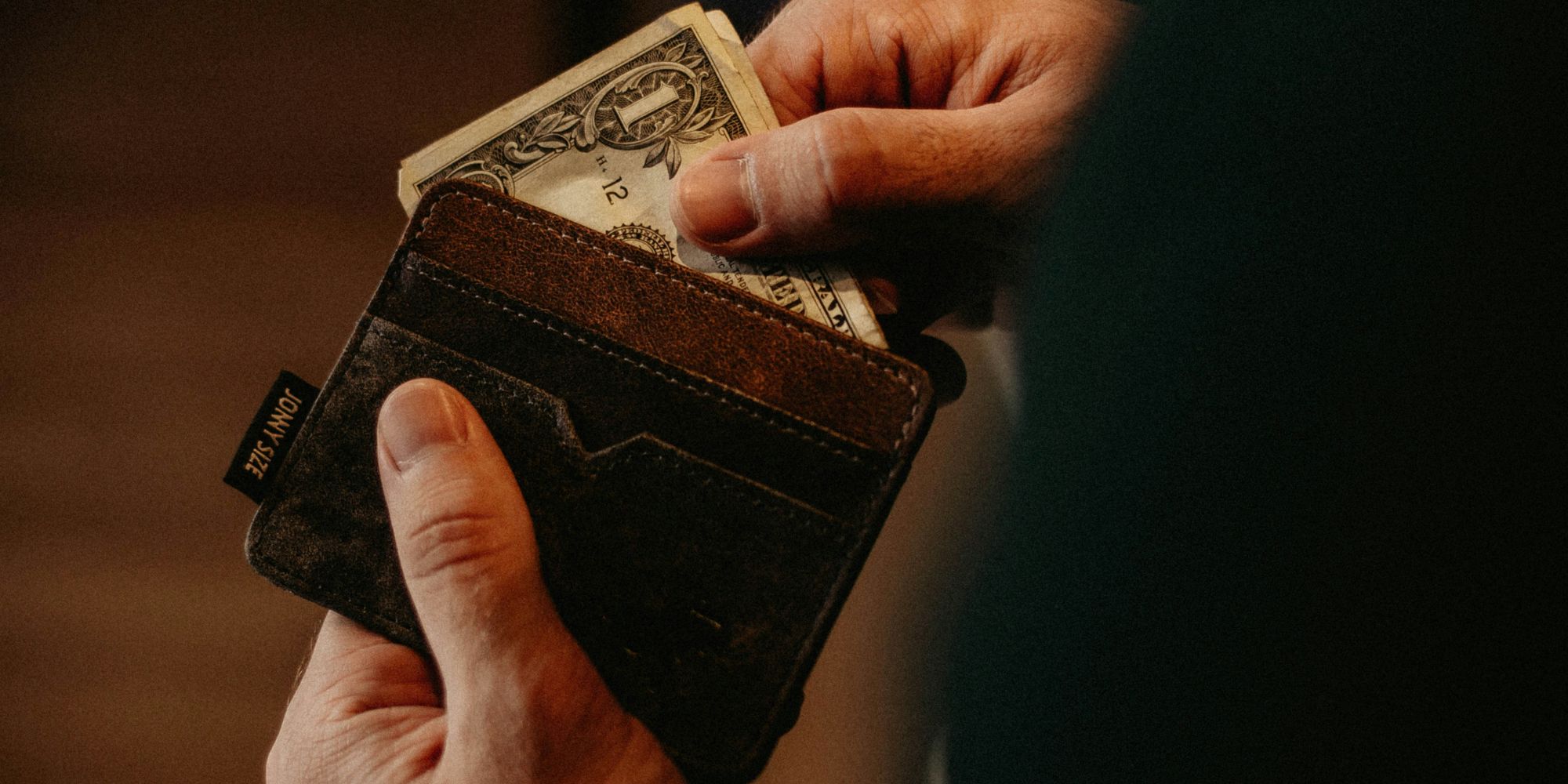 Man pulling money from a wallet to manage kitchen remodeling costs in Portsmouth, NH