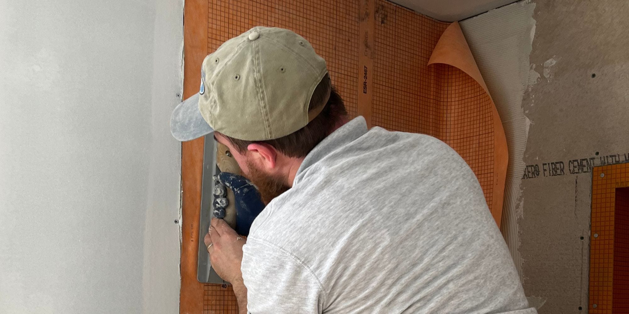 Contractor installing waterproofing membrane in a tile shower installation in Portsmouth, NH