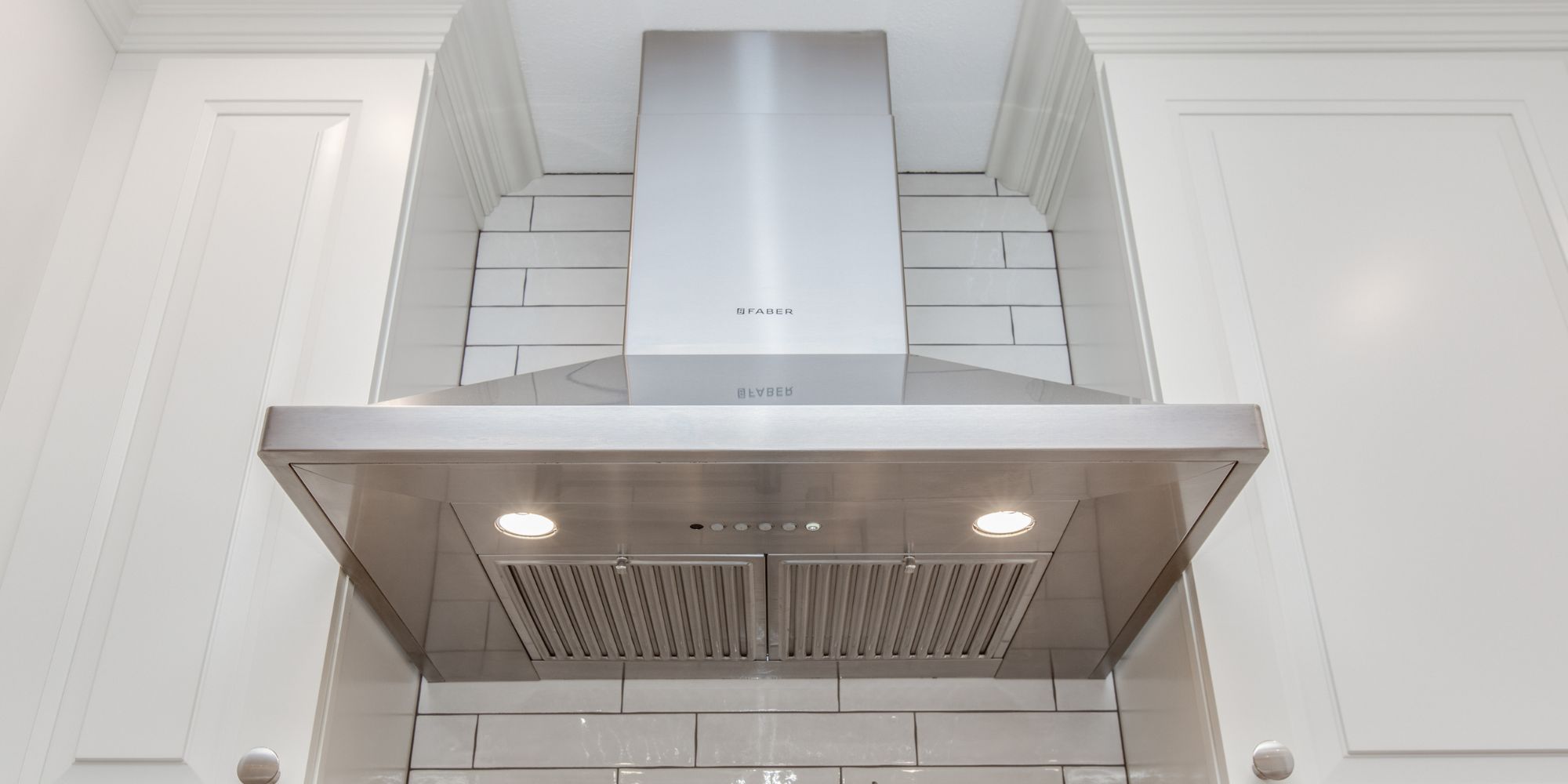Kitchen remodel with a stainless steel vent hood and tile backsplash in Portsmouth, NH