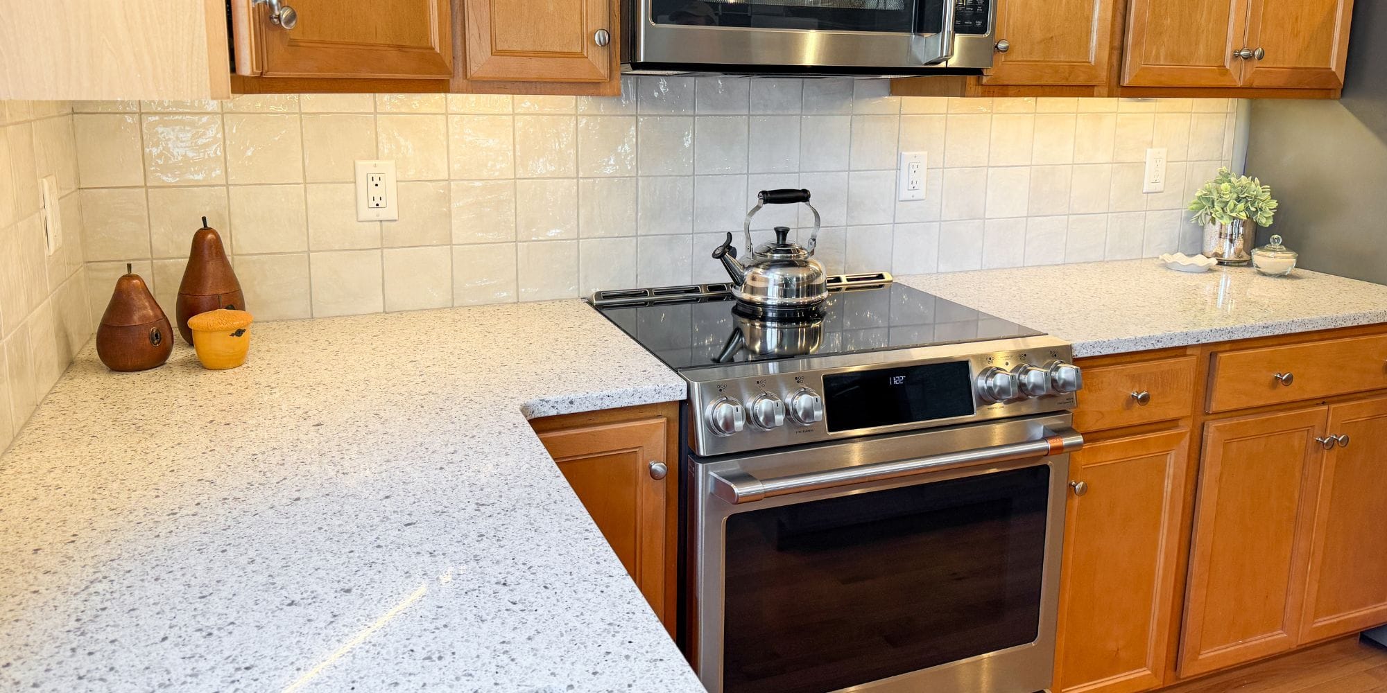 Kitchen refresh with quartz countertops, tile backsplash, and undercabinet lights in Dover, NH