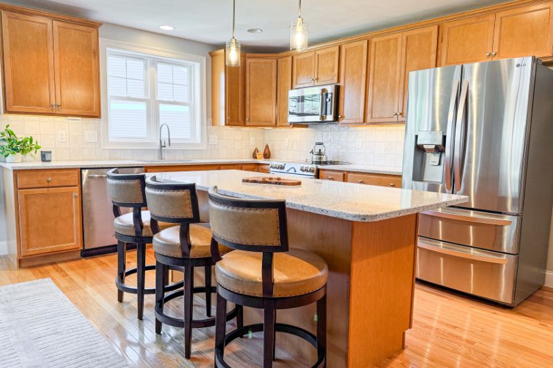 Kitchen renovation in North Hampton, NH with undercabinet lighting, quartz countertops, and tile backsplash