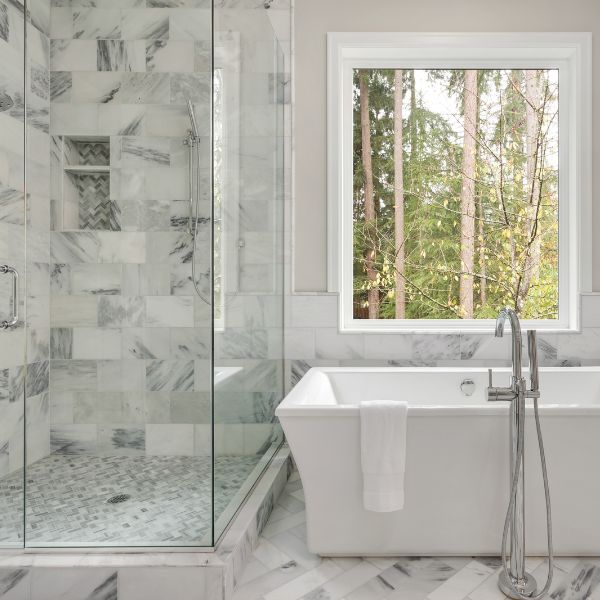 Master bath remodel in Rye, NH with a tiled shower, custom shower glass, and freestanding soaker tub