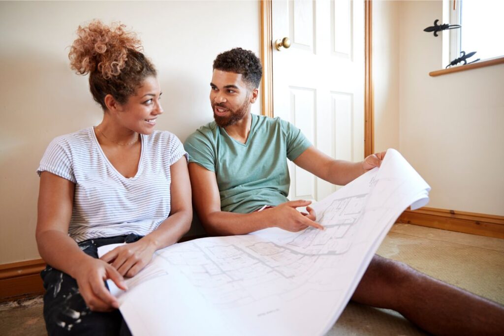 Young couple reviews blueprints for a home remodel in Dover, NH