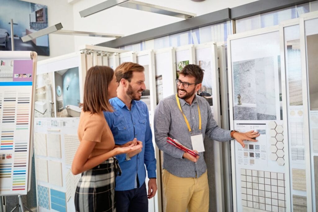 Flooring store associate helps a couple choose tile for their remodel.